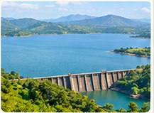 Dam and surrounding green hills shown in the supplied reference image